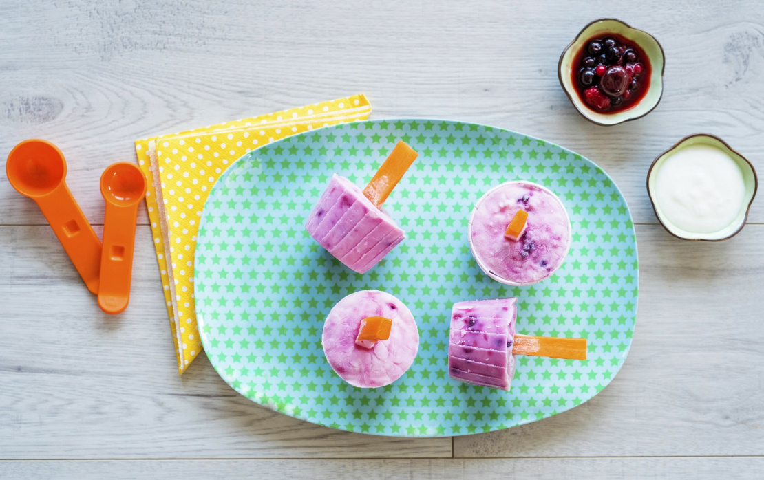 Eiscreme mit Joghurt und Früchten am Karottenstiel